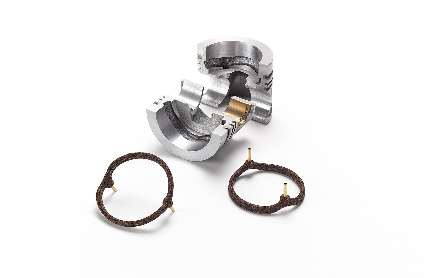 Ein silbernes Metallstück und braune Salzkerne für die Gießereitechnik