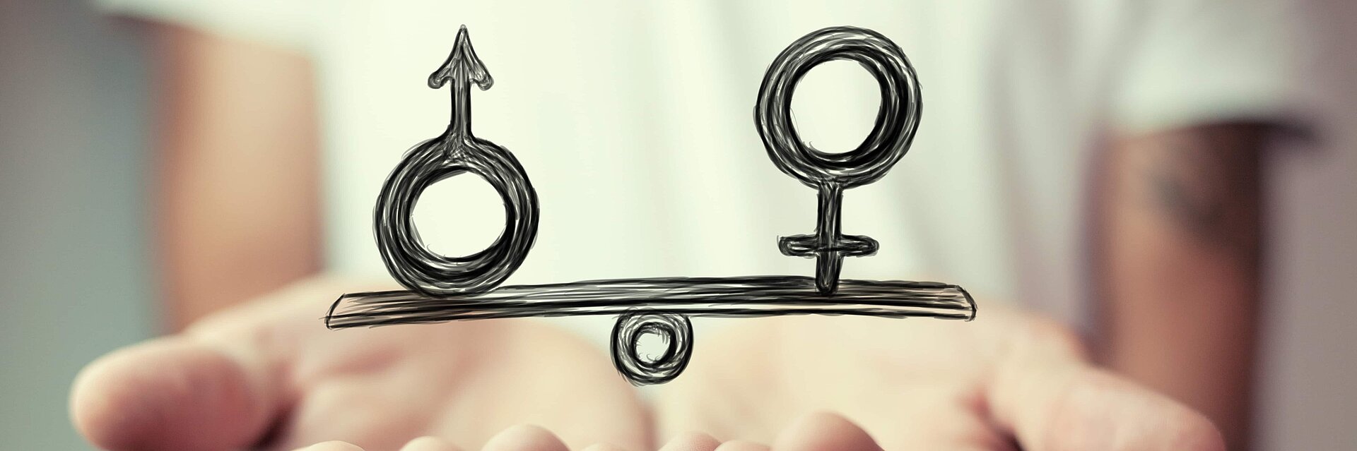 A hand and a scale symbolise the gender pay gap