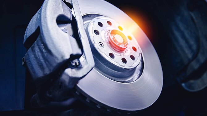 Closeup steel brake disk and detail of wheel hub with sunlight