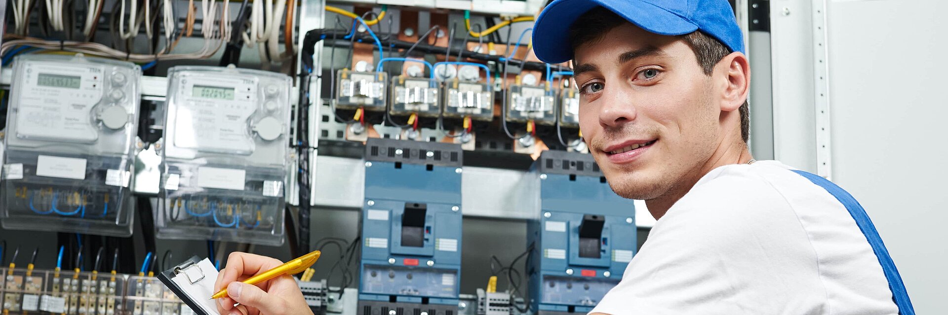 Auszubildender sitzt an einem Schaltschrank