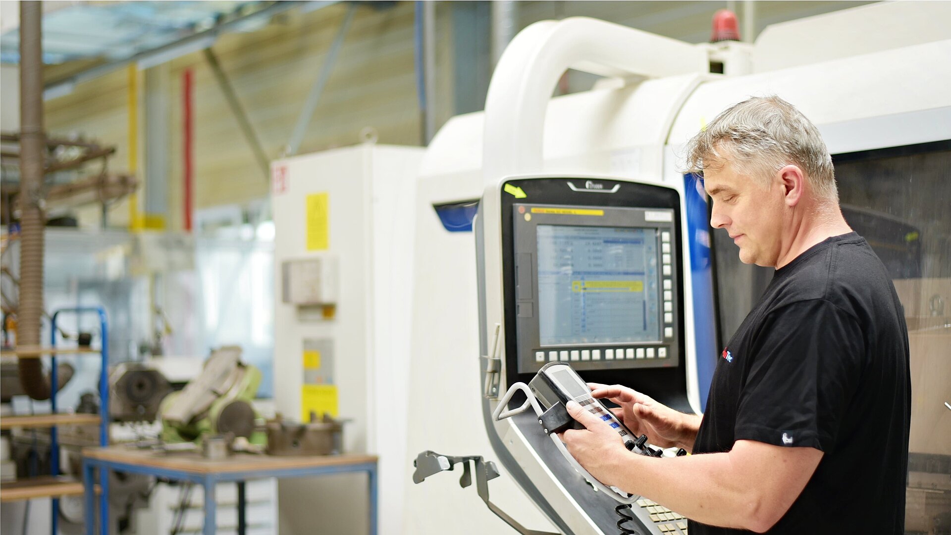 Zaměstnanec společnosti CeramTec v Šumperku v České republice obsluhuje CNC stroj.