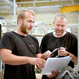 Dva zaměstnanci společnosti CeramTec v Šumperku v České republice obsluhují stroj na broušení.