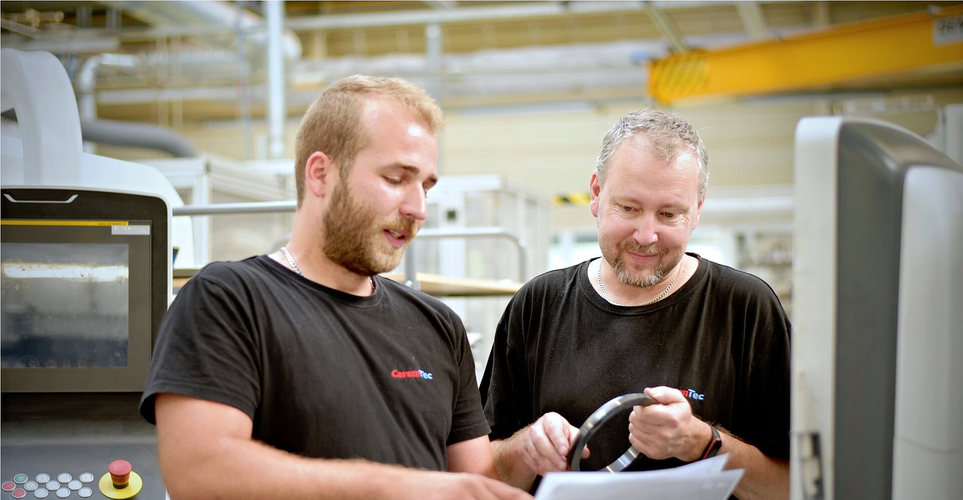 Dva zaměstnanci společnosti CeramTec v Šumperku v České republice obsluhují stroj na broušení.