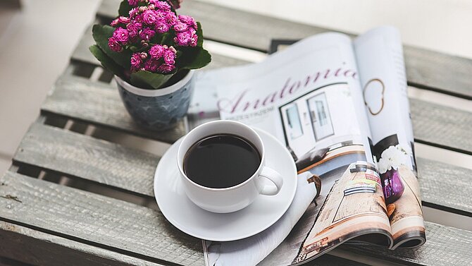 A cup of coffee with a magazine